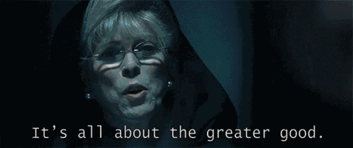 a woman says it 's all about the greater good in a dark room|833x351.26506024096386